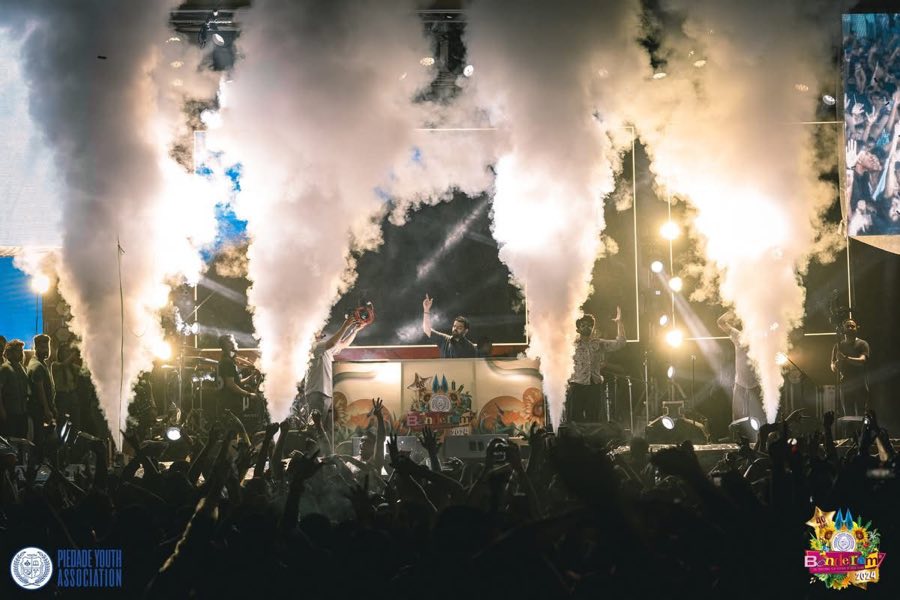 The main stage at night with smoke cannons and a huge crowd