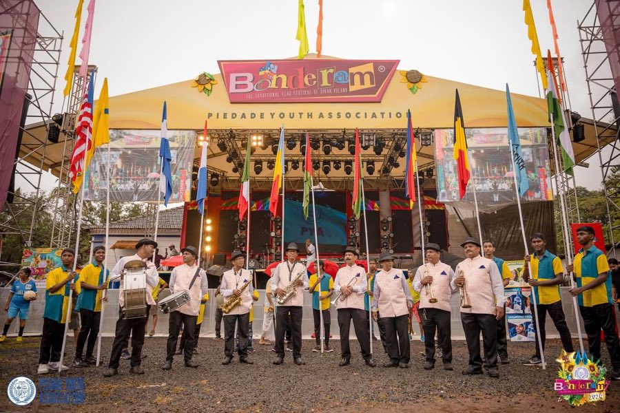 A brass band and flag bearers in front of the Bonderam stage