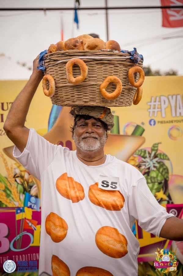 A traditional Goan poder balancing a basket of bread on his head